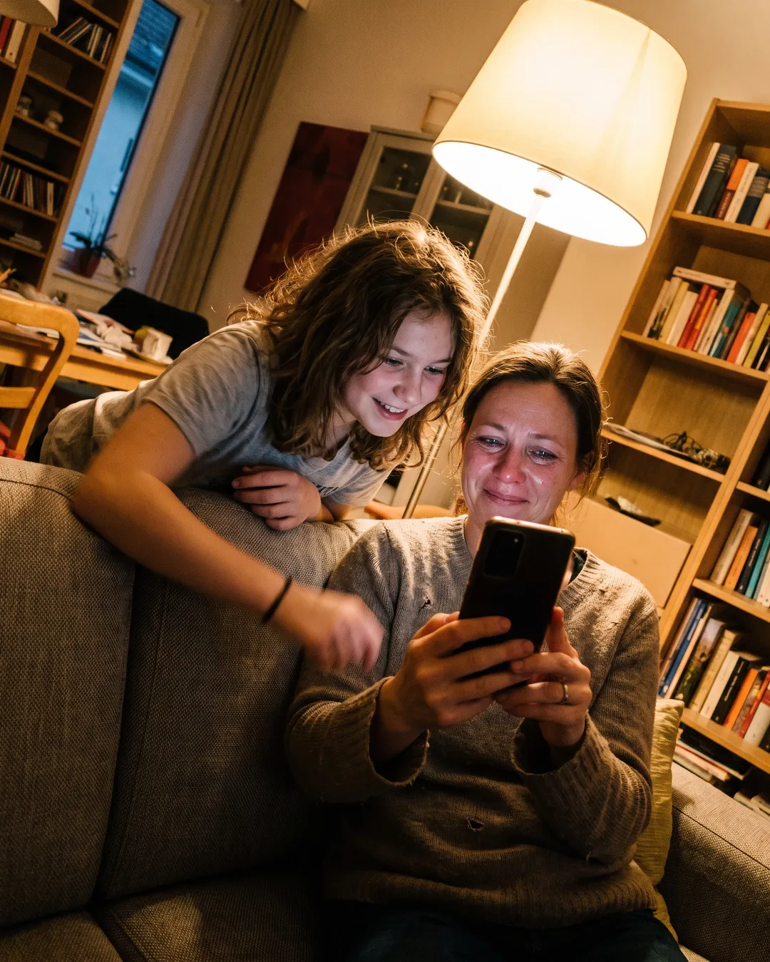 Tochter überrascht die Mama am Sofa